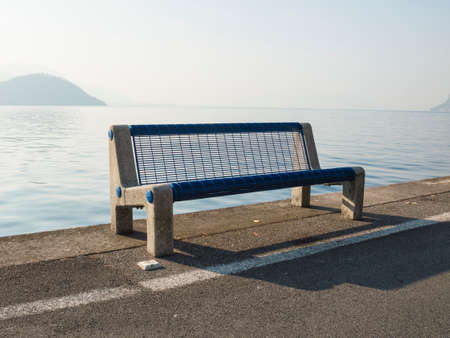 Empty bench near the river of a lakeの写真素材