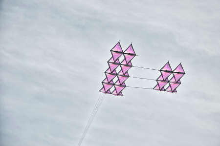 Colorful airplane shape Kite flying in a cloudy skyの写真素材