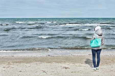 Young woman looking the sea from the beach