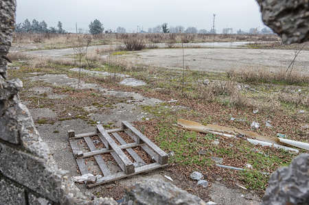 Old damaged pallet, concept of business failure, view through broken wallの写真素材
