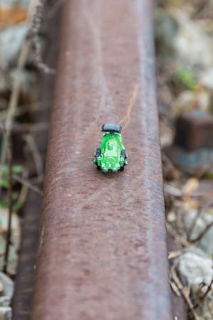Green steel toy train in a blurred background, conceptual photoの写真素材
