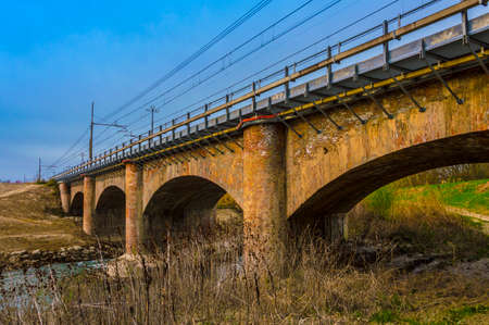Rural Stone Road Bridge Crossing River With Beautiful Landscape, saturated photoの写真素材