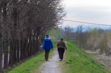 Old couple walking during spring weather in afternoon hoursの写真素材