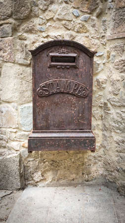 Close up view of an old decaying mailbox hanging on a wall