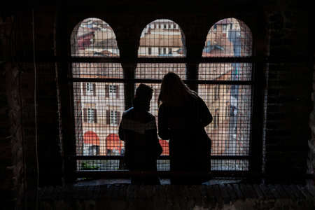 Europe travel mother and son looking throught big window of and old medieval steeple