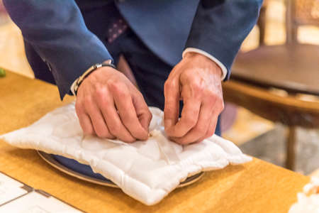 Groom takes wedding rings from lace pillowの写真素材
