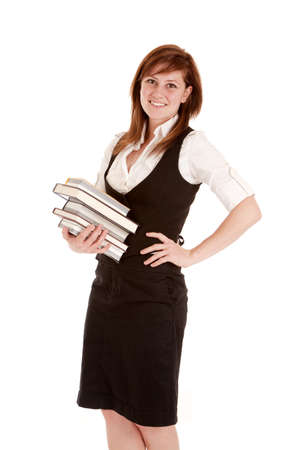 A woman with a smile on her face holding on to a stack of books.の写真素材