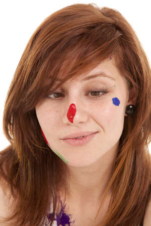 A close up of a woman's face with her looking at her nose with paint on it.の写真素材