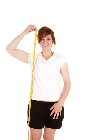 A woman measuring how tall she is with a smile on her face.の写真素材