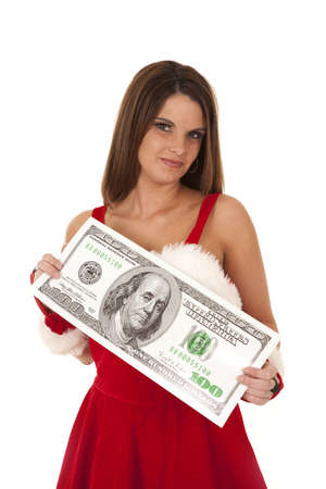 a woman in Mrs. Santa outfit holding on to a big one hundred dollar bill.の写真素材