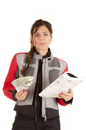 a woman holding a map in one hand and in the other a  bunch of money with a confused expression on her face.の写真素材
