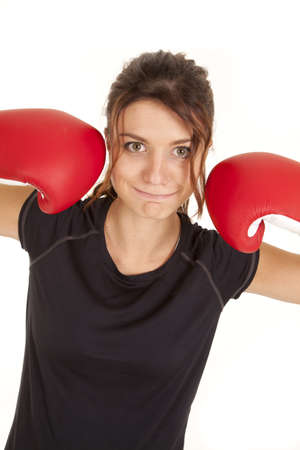 A woman with a funny expression on her face with her boxing gloves up by her face.の写真素材