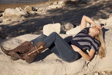 A woman laying on the a rock relaxing and getting some sun.の写真素材