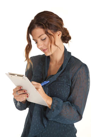 a woman taking notes and looking at what she is writing.