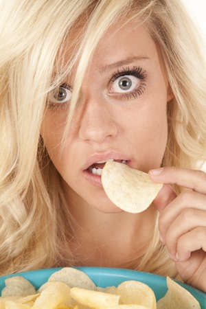  A woman getting ready to eat one of the many potato chips she has to eat の写真素材