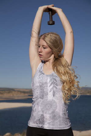 A woman working out in the outdoors with  a weight.の写真素材