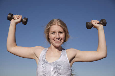 A woman working out in the outdoors with  a weight.の写真素材
