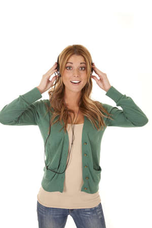 A woman listening to her music through her headphones with a smile on her face.の写真素材