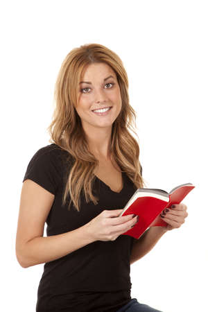 a woman with a huge smile on her face holding her book open.の写真素材