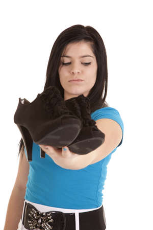 A girl with a serious expression holding out her shoes.の写真素材