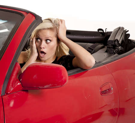 a woman looking out her front windshield  with a scared expressionon her face.の写真素材