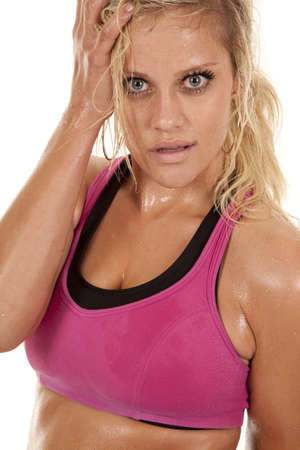 A woman with sweat on her and a pink sports bra.の写真素材