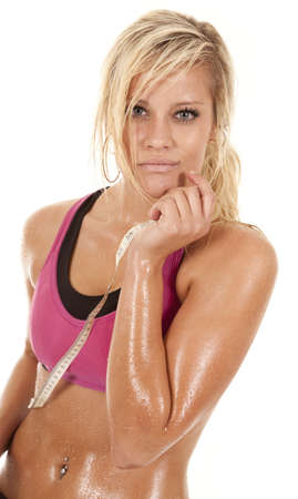 A woman is standing drenched in sweat with a tape.の写真素材