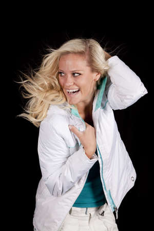 A woman is wearing a white coat in front of a black background.の写真素材