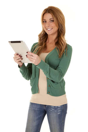 A woman holding on to her tablet with a smile on her face.の写真素材