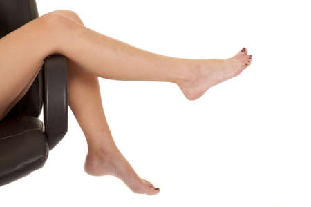 a woman's legs laying over the edge of the chair.の写真素材