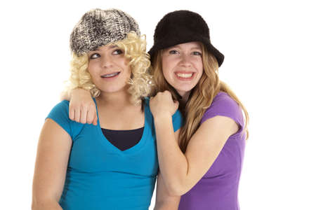 Two teen girls wearing funny hats and wigs with smiles on their faces.の写真素材