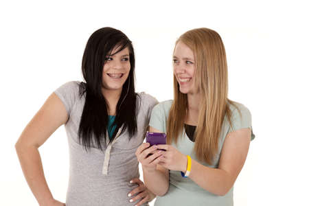 A couple of friends looking at a cell phone text laughing.の写真素材