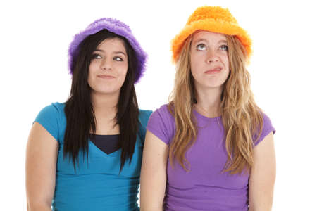 A couple of teen girls wearing a hat with funny expressions on their faces.の写真素材