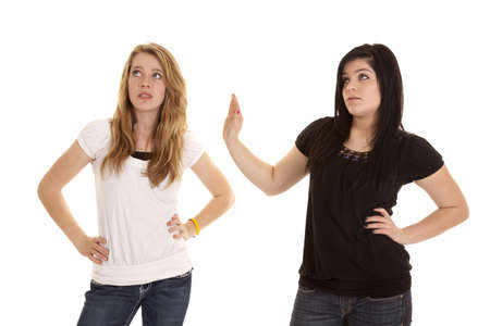 A teen girl putting up her hand to tell the other girl to talk to her hand.の写真素材