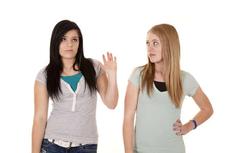 A teen girl putting up her hand to tell the other girl to talk to her hand.の写真素材