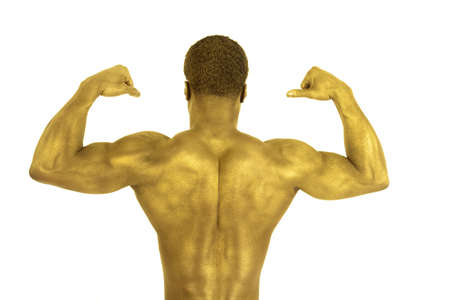 A man flexing his back muscles his skin is gold.の写真素材