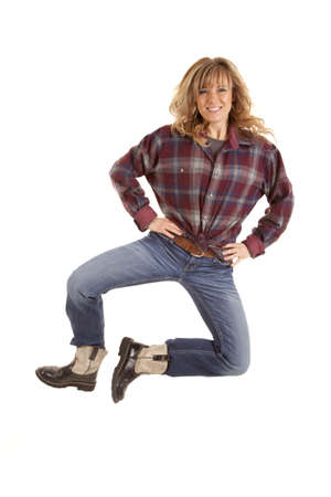 A woman showing her excitement jumping up in the air wearing cowboy boots.の写真素材