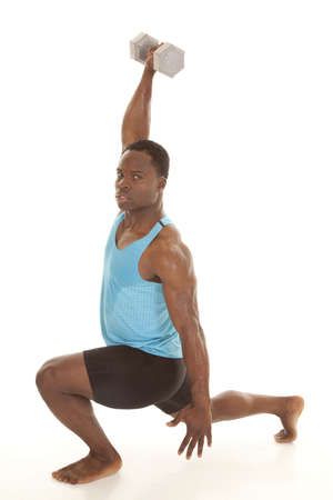 A man in a lunge looking at the camera while lifting up a weightの写真素材