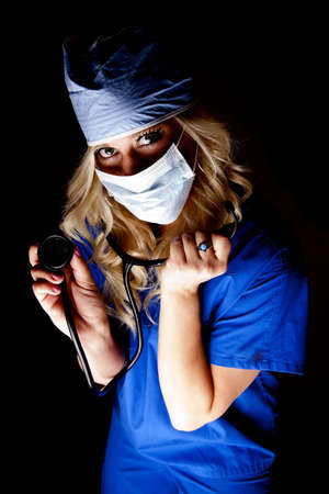 A woman doctor or nurse with a stethoscope in the dark.の写真素材