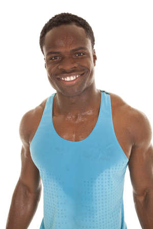 A man with sweat on his shirt and body with a big smile on his face.