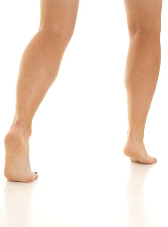 A woman walking away from the camera in her bare feet.の写真素材