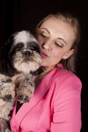 A woman with her lips puckered getting ready to kiss her dog.の写真素材