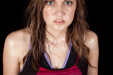 A woman is wet and sweaty with a serious expression.の写真素材