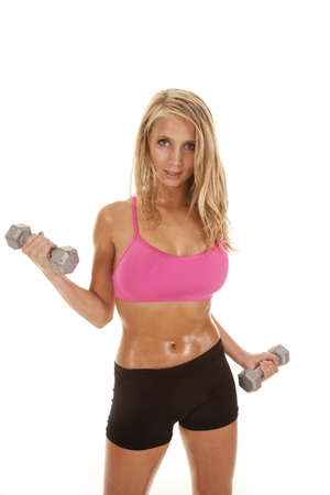 A woman with an intense look lifting weights.の写真素材