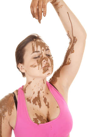 A woman's hand dripping mud onto her face.の写真素材