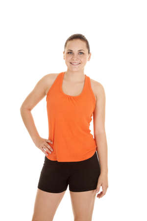 A woman with her hand on her hip with a smile on her lips in her fitness clothes.の写真素材