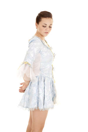 a girl in her blue dress looking down with  a peaceful expression on her face.の写真素材