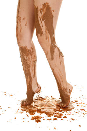 A woman's legs dripping with mud down her leg and off her toesの写真素材