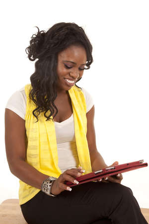 A woman looking down at her electronic tablet with a smile on her faceの写真素材