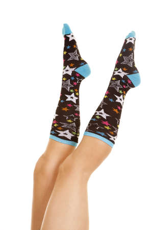 A woman has her legs up in the air with sock on with a star design.の写真素材